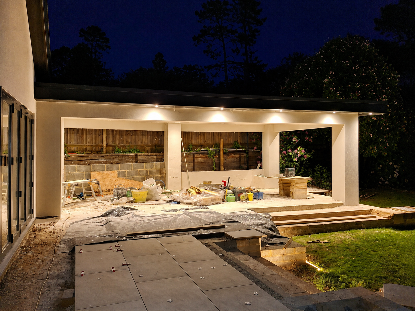 Night photo of a house extension with a lit covered terrace