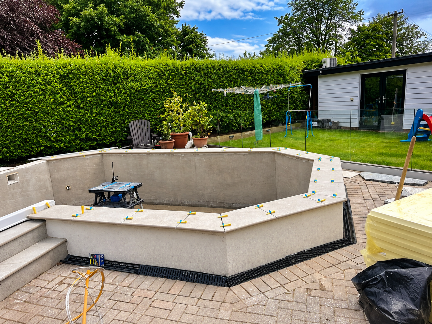 Swimming pool shell being finished with mosaic tiles